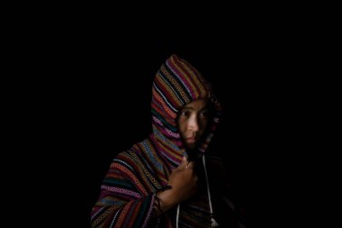 Siyah arka planda kapüşonlu palto giyen bir adam. Moda ve şık erkek kavramı. 