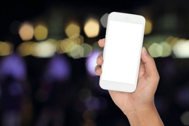 Soyut bulanık bokeh arkaplan üzerinde akıllı telefon ile el.