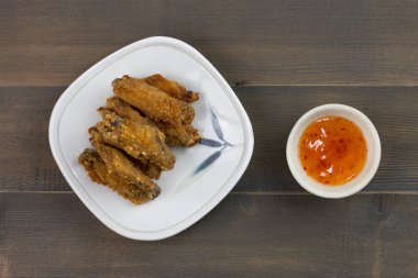 Ahşap masada soslu tavuk kanadı.