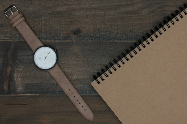 木制桌子上的腕表和笔记本 — 图库照片