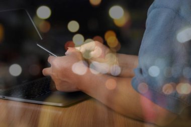 Akıllı telefon ve bilgisayar kullanan bir adam interneti ofis masasında, çevrimiçi, çalışıyor, iş ve teknoloji, Bokeh light arka planında internet ağı iletişimi.