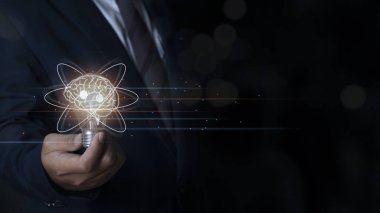 Businessman holding light bulb with brain inside, Creative and innovation inspiration, Science innovation with network connection, Idea and imagination, Concept of innovative technology presentation.