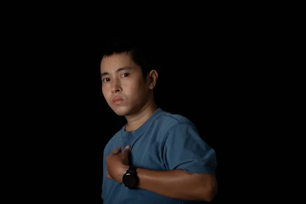 Portrait of asia man with a smart wath and wearing a blue t-shirt on black background.