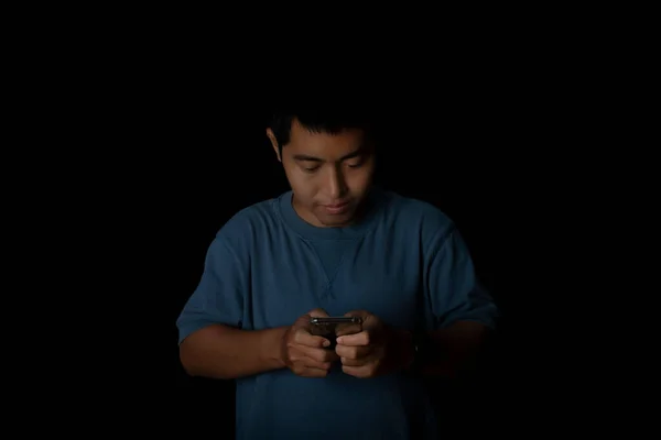 Portrait Young Man Wearing Blue Shirt Using Smartphone Black Background — Stockfoto