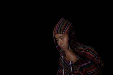 Siyah arka planda kapüşonlu palto giyen bir adam. Moda ve şık erkek kavramı.