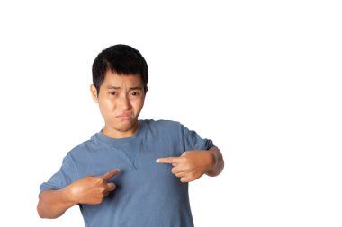 Portrait of young man wearing casual t-shirt pointing at self, himself, studio shot isolated on white background.