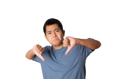 Portrait of young man showing thumb down sign by hand, unhappy, angry show rejection and negative with thumb down gesture. bad expression. studio shot isolated on white background. copy space.