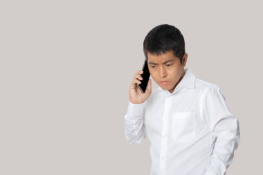 Portrait of businessman talking smartphone. Human emotion face expression concept. Studio shot isolated on gray background. copy space.