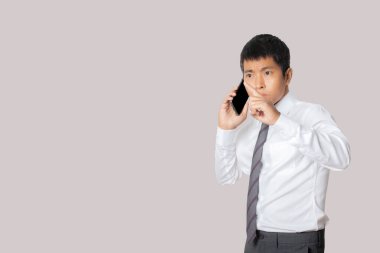 Portrait of businessman talking smartphone. Human emotion face expression concept. Studio shot isolated on gray background. copy space.