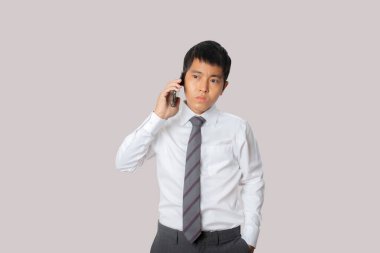 Portrait of businessman talking smartphone. Human emotion face expression concept. Studio shot isolated on gray background. copy space.