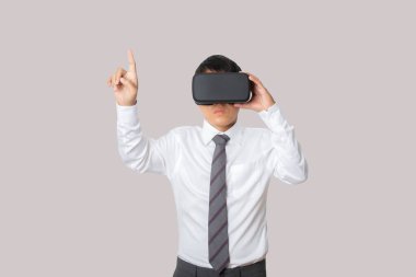 Studio portrait businessman wearing VR Headset touching something isolated on gray background. Glasses of virtual reality. Technology, gaming, entertainment and people concept. copy space.