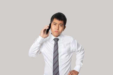 Portrait of businessman talking smartphone. Human emotion face expression concept. Studio shot isolated on gray background. copy space.