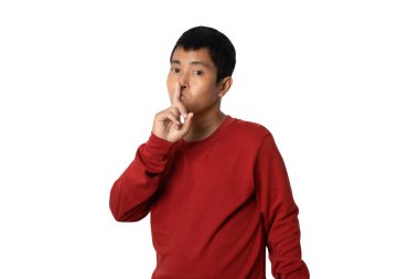 Portrait of young man making hush gesture and keep conspiracy. Silence and secret and human emotion face expression concept. Studio shot isolated on white background. copy space.