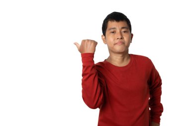 Portrait of young man pointing thumb aside at blank space for text. Presenting gesture. Human emotion face expression concept. Studio shot isolated on white background. copy space. 