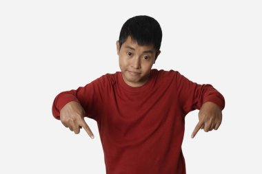 Portrait of young man pointing down with his finger. presenting gesture. Human emotion face expression concept. Studio shot isolated on white background. copy space.