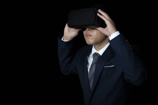 Studio portrait man wearing VR Headset on black background. Glasses of virtual reality. Technology, metaverse, gaming, entertainment and people concept. copy space.