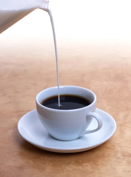 Pouring milk in coffee — Stock Photo, Image