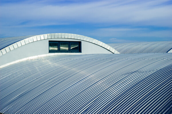 A metallic roof and a nice blue sky with white clouds