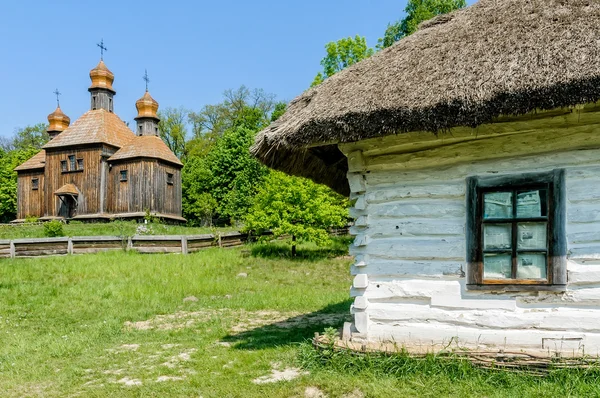 Eine typisch ukrainische antike orthodoxe Kirche, mit einem Haus im Vordergrund — Stockfoto