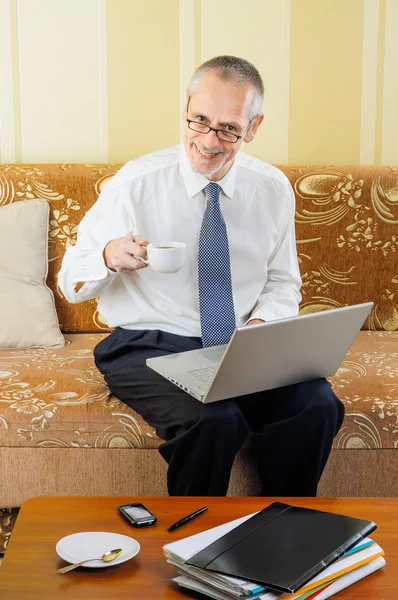 Senior-Geschäftsmann mit Computer beim Kaffeetrinken — Stockfoto