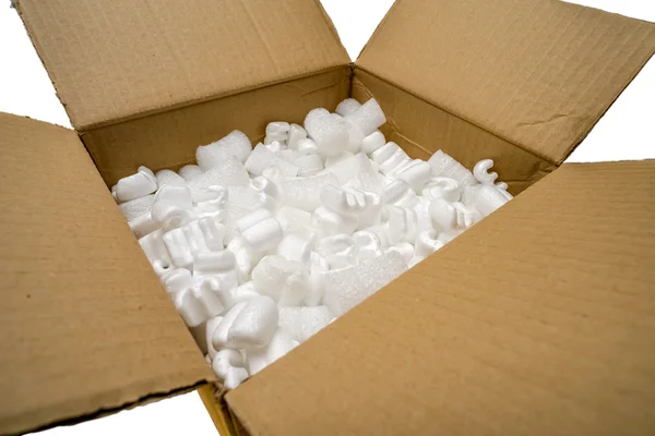 Una caja de cartón con embalaje de relleno Cacahuetes —  Fotos de Stock