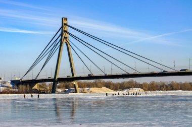 Soğuk bir kış boyunca Ukrayna 'nın Kiev kentindeki Obolon bölgesinde donmuş Dinyeper' deki balıkçılar. Arka planda Pivnichnyi (eski Moskovsky) köprüsü.
