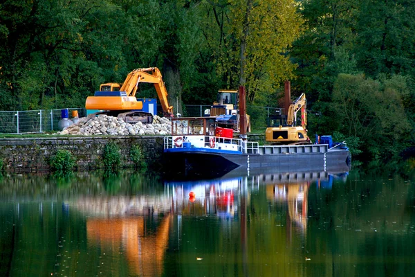 Gele graafmachine en barge — Stockfoto