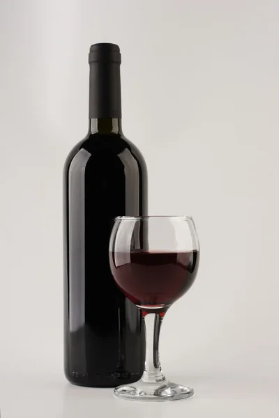 Flaska rött vin med glas — Stockfoto