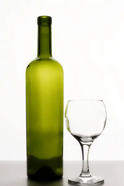 Lege fles wijn en een glas wijn — Stockfoto