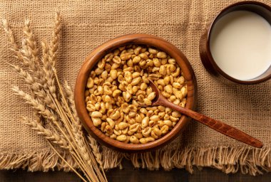 Tahta kasede mısır gevreği kahvaltısı ve arka planda kuru çivili çiviler. Seçici odak.