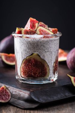 Sağlıklı chia pudingi. Kırsal arka planda incir parçaları var. Seçici odaklanma. Sığ alan derinliği.