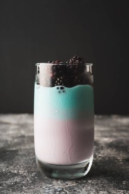 Yoğurtlu tatlı ve koyu kırsal arka planda camlı böğürtlen. Seçici odaklanma. Sığ alan derinliği.