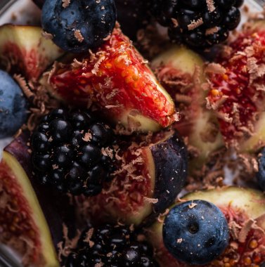 Sağlıklı chia pudingi. Kırsal arka planda incir ve koyu renkli böğürtlen. Seçici odaklanma. Sığ alan derinliği.