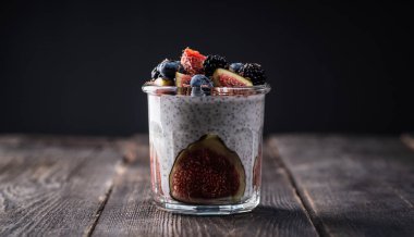 Kırsal arka planda yabanmersini kavanozlu sağlıklı chia pudingi. Seçici odaklanma. Sığ alan derinliği.