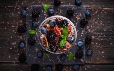Kırsal arka planda yabanmersini kavanozlu sağlıklı chia pudingi. Seçici odaklanma. Sığ alan derinliği.