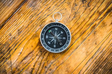 Pusula eski ahşap tahta üzerinde yatıyor. Yukarıdan vurulmuş. Sonbahar arkaplanı.