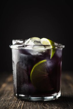 Cin bazlı eski tarz siyah kokteyl. Seçici odak.