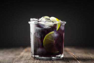 Cin bazlı eski tarz siyah kokteyl. Seçici odak.