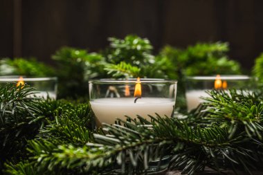 Yeşil çam dallarında yanan mum. Noel arkaplanı. Seçici odak.