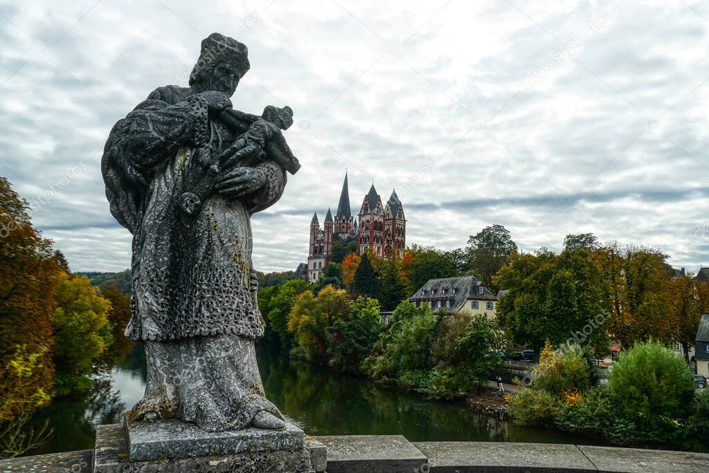 Historical statue on a bridge and cathedral in Limburg Lahn