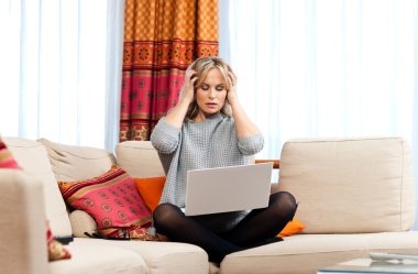 çekici bir kadın laptop ve baş ağrısı ile