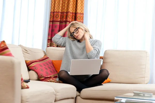 Mulher atraente com laptop com dor no pescoço — Fotografia de Stock