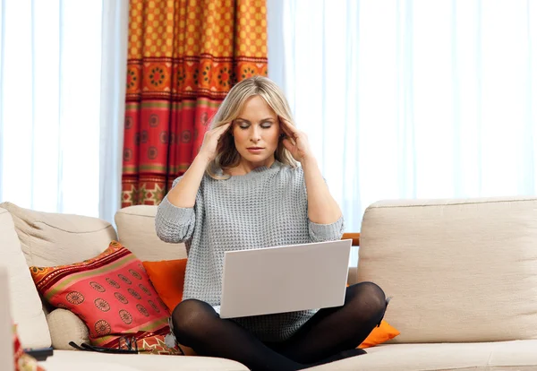 Femme attrayante avec ordinateur portable ayant la migraine — Photo