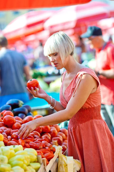 Woman on market place with vegetables Stock Image