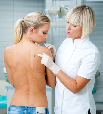 doctor inspecting woman patient skin clipart
