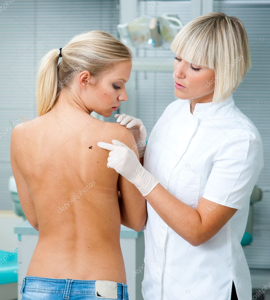 doctor inspecting woman patient skin