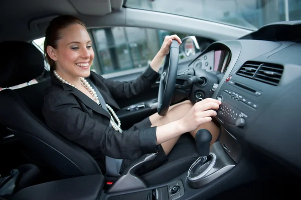 Frau fährt Auto und wechselt Radiosender — Stockfoto
