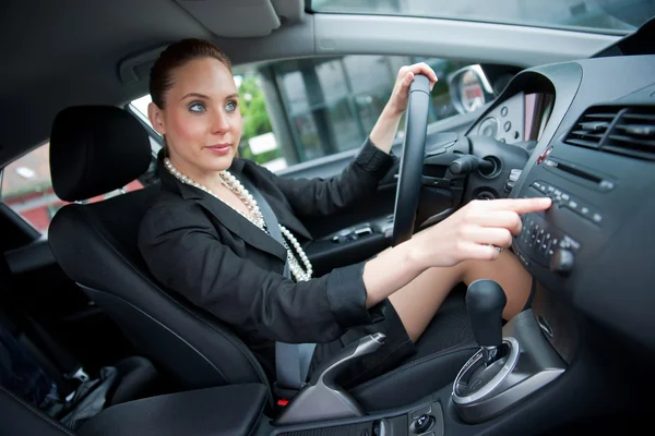 Woman driving and changing radio station — Stock Photo, Image