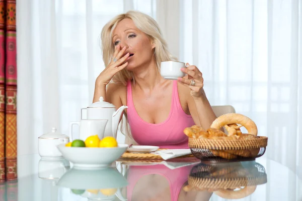 Kvinna gäspar på frukostbordet — Stockfoto