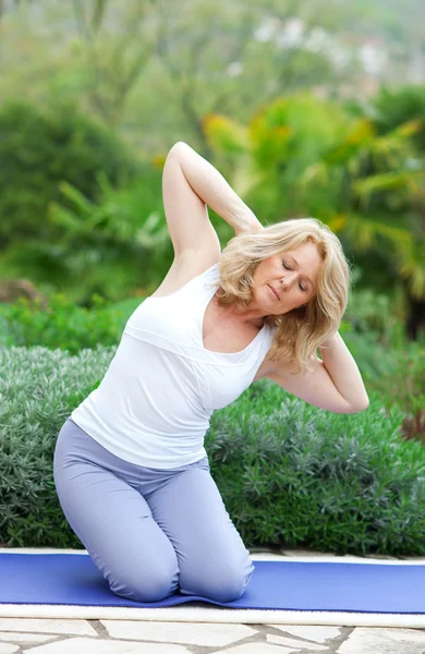 Mujer madura en posición de yoga — Foto de Stock